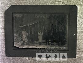 Groupe de sept hommes inconnus devant une cabane de chantier