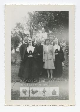 Religieuses Routhier et leur famille devant la statue de la Vierge dans le jardin du couvent