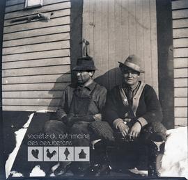 Deux hommes inconnus assis devant un bâtiment