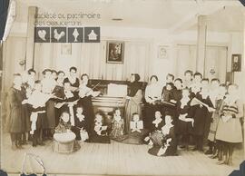 Groupe de vingt-huit étudiantes et d’une religieuse dans la classe de musique du couvent